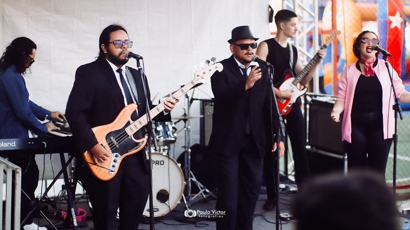 Banda se apresentando em palco ao ar livre