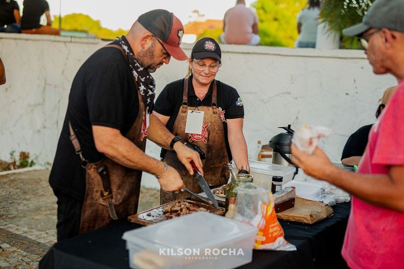 Cozinheiros preparando carne na praça de alimentação